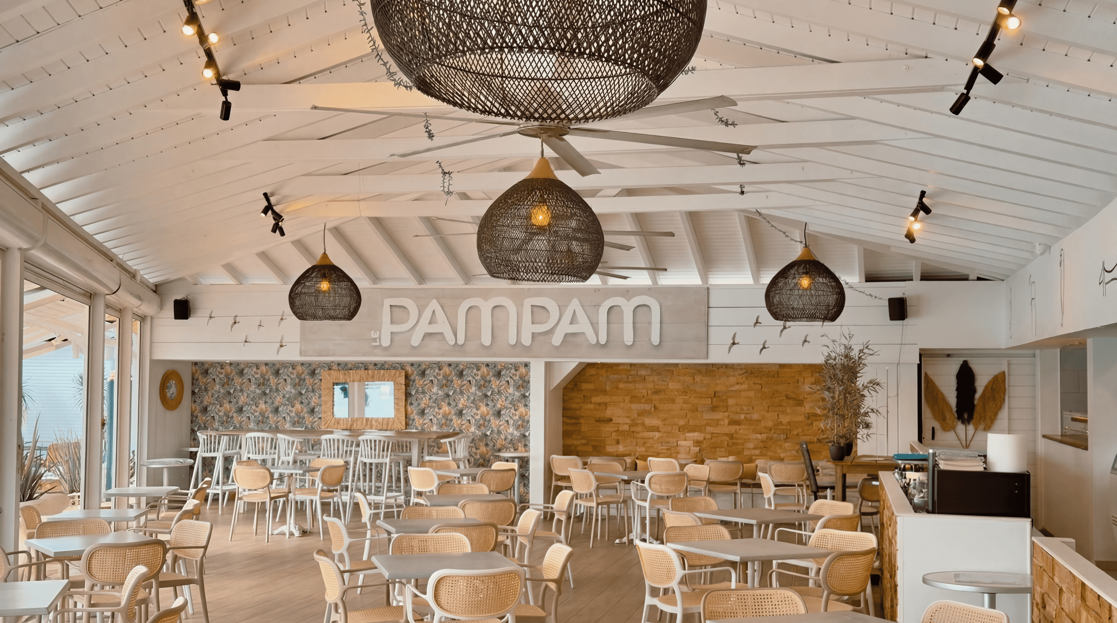Intérieur du PamPam, Charpente blanche, suspensions rotin, ambiance bohème.